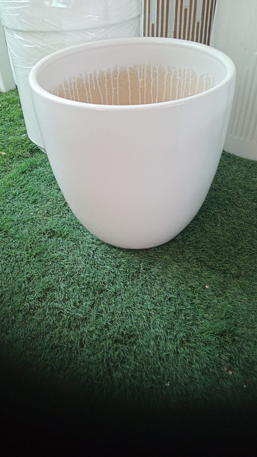 Large white ceramic planter pot on artificial grass, ideal for indoor or outdoor plants