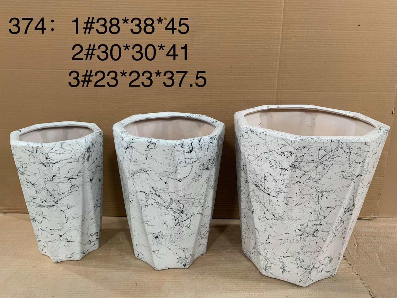 Set of three white marble-patterned plant pots in different sizes, displayed indoors.