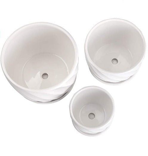 Set of three white ceramic plant pots with drainage holes, ideal for indoor gardening