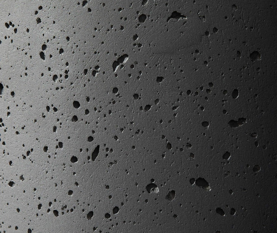 Close-up of dark grey fiberstone planter pot surface with porous texture