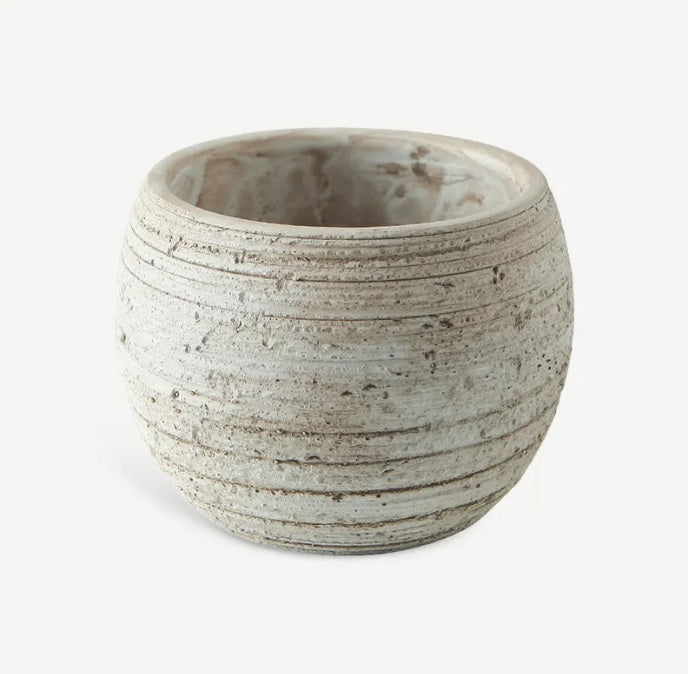 Round fiber cement planter pot with textured surface and horizontal grooves on white background