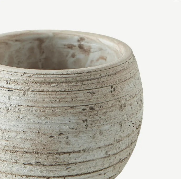 Round fiber cement planter pot with rustic textured finish and horizontal grooves