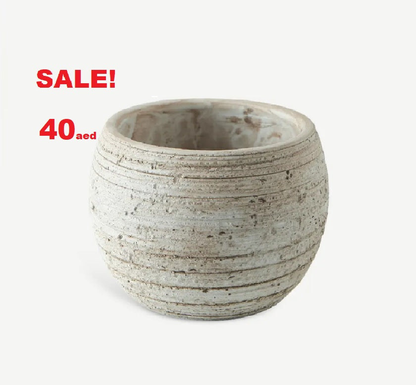 Round fiber cement plant pot with textured surface, on sale for 40 AED