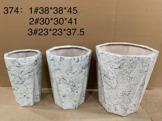 Set of three white marble-patterned plant pots in different sizes, displayed indoors.