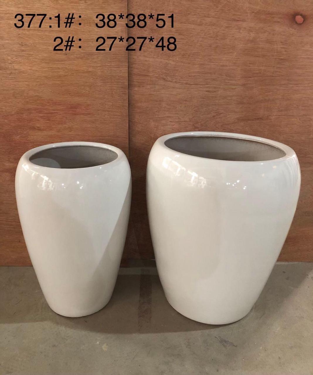 Two white ceramic plant pots in different sizes with size dimensions on a wooden background.
