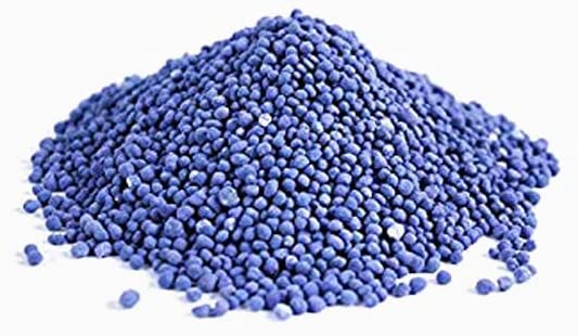Pile of blue granular plant fertilizer on white background