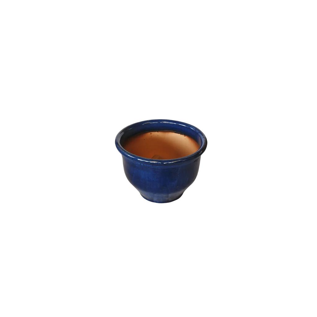 Round blue ceramic plant pot with wide rim and terracotta interior on white background